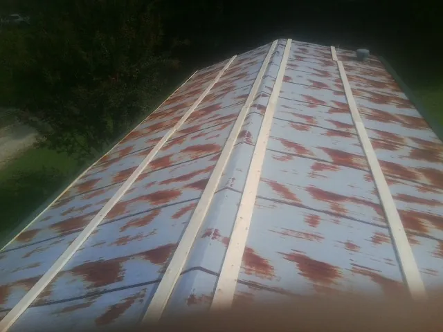 Rusted metal roof panels with new wood purlins before replacement — Storm Damage Roof Repair in Fort Covington by Roofing Brothers